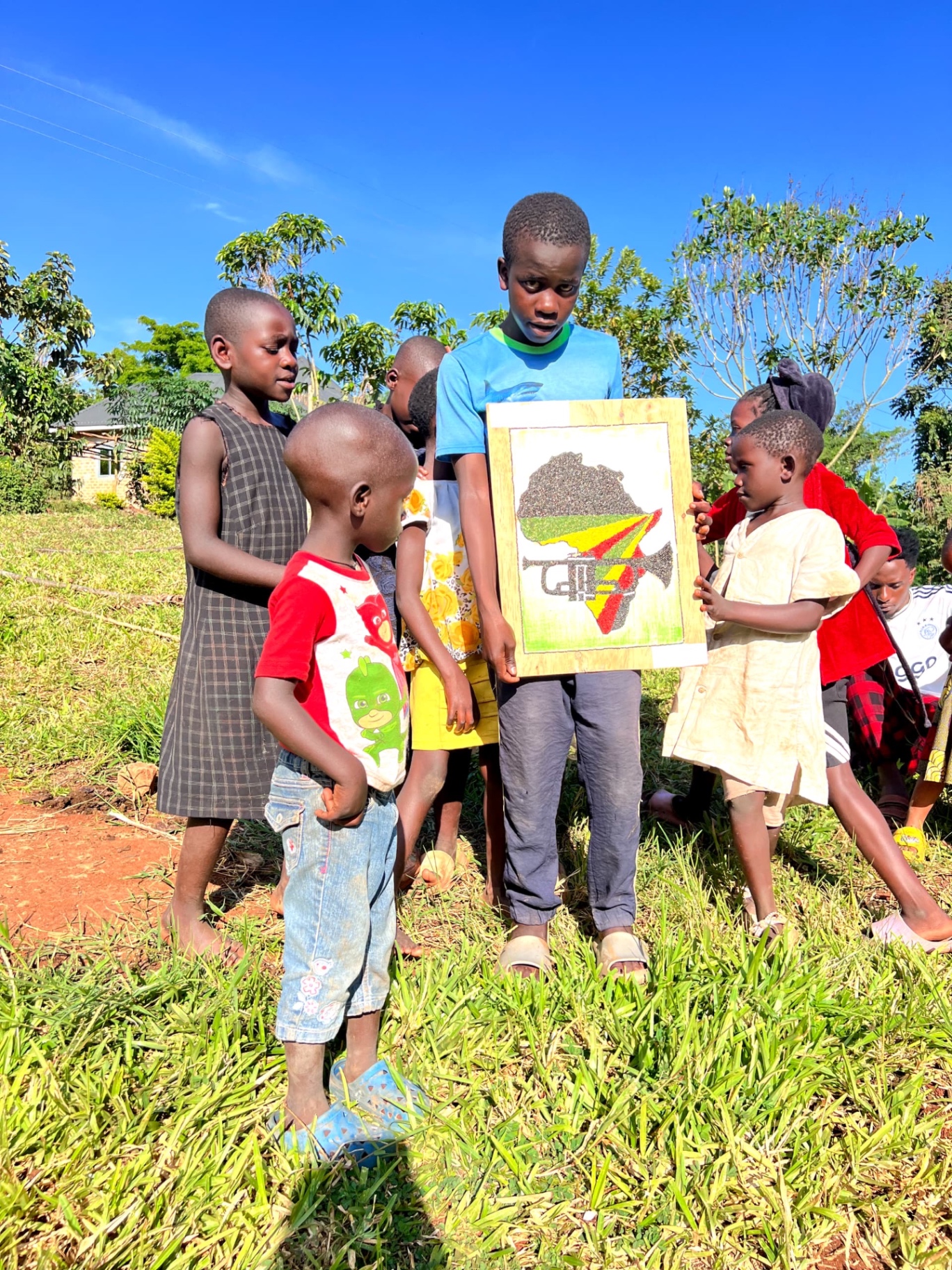 Children holding a handmade Africa artwork